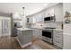 Bright kitchen features stainless steel appliances, a center island, and wood-look flooring at 1211 S Druid Ln, Tampa, FL 33629