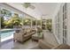 Enclosed patio with comfortable seating, ceiling fans, and views of the backyard swimming pool at 1211 S Druid Ln, Tampa, FL 33629