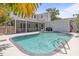 A refreshing in-ground pool sits between the main house and pool house with a screened-in porch in the background at 1211 S Druid Ln, Tampa, FL 33629