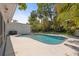 A lovely in-ground pool with a concrete surround is surrounded by green trees in a fenced backyard at 1211 S Druid Ln, Tampa, FL 33629