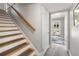 Staircase with carpet runner and wood railing, and entry door with decorative glass at 1211 S Druid Ln, Tampa, FL 33629