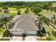 This aerial view showcases the home's roof, landscaping, and proximity to a serene pond at 1216 Lyndhurst Greens Dr, Sun City Center, FL 33573