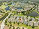 Beautiful aerial view of the community with ponds, lush golf courses, and well-maintained homes with mature landscaping at 1216 Lyndhurst Greens Dr, Sun City Center, FL 33573