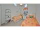 Bright bedroom featuring twin beds, a white bookshelf, and round windows providing natural light at 1216 Lyndhurst Greens Dr, Sun City Center, FL 33573