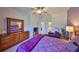 The bedroom features wood furniture, is painted light purple and is illuminated by a ceiling fan at 1216 Lyndhurst Greens Dr, Sun City Center, FL 33573