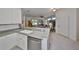 Open concept kitchen features white cabinets, stainless steel appliances, and flows into the living area at 1216 Lyndhurst Greens Dr, Sun City Center, FL 33573