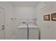 The laundry room has a washer and dryer with tiled floors, a utility shelf and access to the exterior at 1216 Lyndhurst Greens Dr, Sun City Center, FL 33573