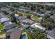 An aerial view of a residential neighborhood with manicured lawns, private pools, mature trees, and a winding road at 13057 89Th Ave, Seminole, FL 33776