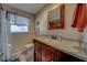 Bathroom featuring wood vanity, granite countertop, large mirror, and neutral tile at 13057 89Th Ave, Seminole, FL 33776