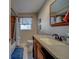 Bathroom featuring wood vanity, granite countertop, large mirror, and neutral tile at 13057 89Th Ave, Seminole, FL 33776