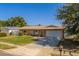 Single-story home boasts a well-manicured front lawn, a paved driveway leading to the attached garage, and classic curb appeal at 13057 89Th Ave, Seminole, FL 33776
