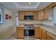 This kitchen showcases wood cabinets, tile flooring and stainless steel oven at 13057 89Th Ave, Seminole, FL 33776