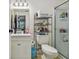Well-lit bathroom with updated vanity, shower, and storage shelving at 134 Sycamore Ln # H, Oldsmar, FL 34677