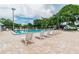 Community pool area with lounge chairs, surrounded by palm trees and greenery, offering a relaxing outdoor experience at 134 Sycamore Ln # H, Oldsmar, FL 34677