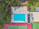 Aerial view of community pool, hot tub, and lounge chairs surrounded by lush landscaping, ideal for relaxation and recreation at 134 Sycamore Ln # H, Oldsmar, FL 34677