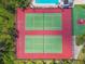 Aerial view of two well-maintained tennis courts with vibrant red and green surfaces, perfect for sports enthusiasts at 134 Sycamore Ln # H, Oldsmar, FL 34677