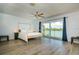 Main bedroom features a simple wood frame bed and sliding glass doors leading to a water view balcony at 135 92Nd Ave # 2, Treasure Island, FL 33706