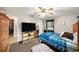 Bedroom with a blue plaid bedspread, fan, TV on shelving, and natural light from the window at 1399 Leeward Ave, Spring Hill, FL 34606