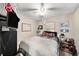 Nicely decorated bedroom with ceiling fan, mounted TV, and window bringing in natural light at 1399 Leeward Ave, Spring Hill, FL 34606