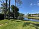 Scenic backyard view of a tranquil pond, lush greenery, and neighboring homes at 14678 Village Glen Cir, Tampa, FL 33618