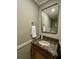 Stylish bathroom featuring a marble countertop vanity, decorative mirror, and modern fixtures at 14678 Village Glen Cir, Tampa, FL 33618