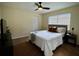 Cozy bedroom with ceiling fan, a queen-sized bed, and a window with horizontal blinds at 14678 Village Glen Cir, Tampa, FL 33618