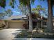 Charming home featuring a manicured lawn, mature trees, and an attached two-car garage at 14678 Village Glen Cir, Tampa, FL 33618