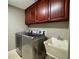 Functional laundry room with a washer, dryer, and a utility sink at 14678 Village Glen Cir, Tampa, FL 33618