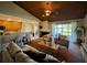 Cozy living room with wood ceiling, fireplace, and sliding glass doors to the backyard and access to kitchen at 14678 Village Glen Cir, Tampa, FL 33618