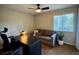 Home office with modern desk, comfortable sofa, and ample natural light from the window at 14678 Village Glen Cir, Tampa, FL 33618
