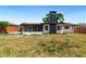 Exterior view of a home with a spacious backyard, including grass and a screened-in porch at 1711 S Patlin Cir, Largo, FL 33770