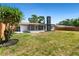 Exterior of a house with a large backyard area that is mostly grass and has a large tree at 1711 S Patlin Cir, Largo, FL 33770