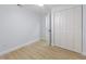 Bright bedroom with a ceiling fan, neutral walls, wood-look flooring, and a closet with louvered doors at 1711 S Patlin Cir, Largo, FL 33770