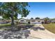 Charming single-story home featuring a long driveway, well-kept lawn, and beautiful mature shade tree in the front yard at 1711 S Patlin Cir, Largo, FL 33770