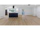 Open-concept living area with luxury vinyl plank flooring, white walls and trim, plus a modern island at 1711 S Patlin Cir, Largo, FL 33770