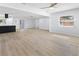Open-concept living area with new ceiling fan, luxury vinyl plank flooring and freshly painted white walls and trim at 1711 S Patlin Cir, Largo, FL 33770