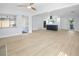 Open-concept living area with new ceiling fan, luxury vinyl plank flooring and freshly painted white walls and trim at 1711 S Patlin Cir, Largo, FL 33770