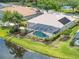 Aerial shot showcasing the screened-in pool, solar panels, and lovely pond view at 18714 Chemille Dr, Lutz, FL 33558