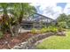 Beautifully landscaped backyard with a patio, enclosed pool, and tropical palm trees at 18714 Chemille Dr, Lutz, FL 33558