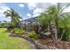 Lush landscaping and a paver pathway surround the screened-in pool and patio area at 18714 Chemille Dr, Lutz, FL 33558