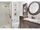 Bathroom featuring a shower, vanity with granite countertop, and a decorative mirror and wall, creating a unique design at 18714 Chemille Dr, Lutz, FL 33558