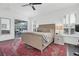 Bright bedroom with a neutral-toned bed, dark wood floors, sliding glass doors and plantation shutters at 18714 Chemille Dr, Lutz, FL 33558