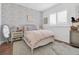 Charming bedroom with floral wallpaper, cozy rug, and natural light from the shuttered window at 18714 Chemille Dr, Lutz, FL 33558