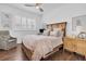 Bedroom featuring a wooden bed frame, shuttered window, and cozy armchair, creating a relaxing retreat at 18714 Chemille Dr, Lutz, FL 33558