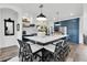 Modern kitchen island with white countertop, seating for six, and stylish pendant lighting overhead at 18714 Chemille Dr, Lutz, FL 33558