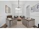 Cozy living room featuring neutral-toned furniture, a chandelier, and plantation shutters, perfect for relaxation at 18714 Chemille Dr, Lutz, FL 33558