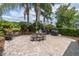 Paver patio with a table, chairs, grill, tropical plants, and a view of the pond at 18714 Chemille Dr, Lutz, FL 33558