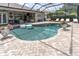 Enclosed pool featuring brick pavers, lounge seating, outdoor entertaining space, and views of the backyard at 18714 Chemille Dr, Lutz, FL 33558