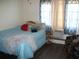 Cozy bedroom with a blue-quilted bed, accent pillows, a side table with basket storage, and a comfortable armchair by the window at 200 N Betty Ln # 5F, Clearwater, FL 33755