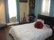 Bright bedroom featuring an inviting bed with unique pillows, musical instruments, and natural light streaming through the windows at 200 N Betty Ln # 5F, Clearwater, FL 33755